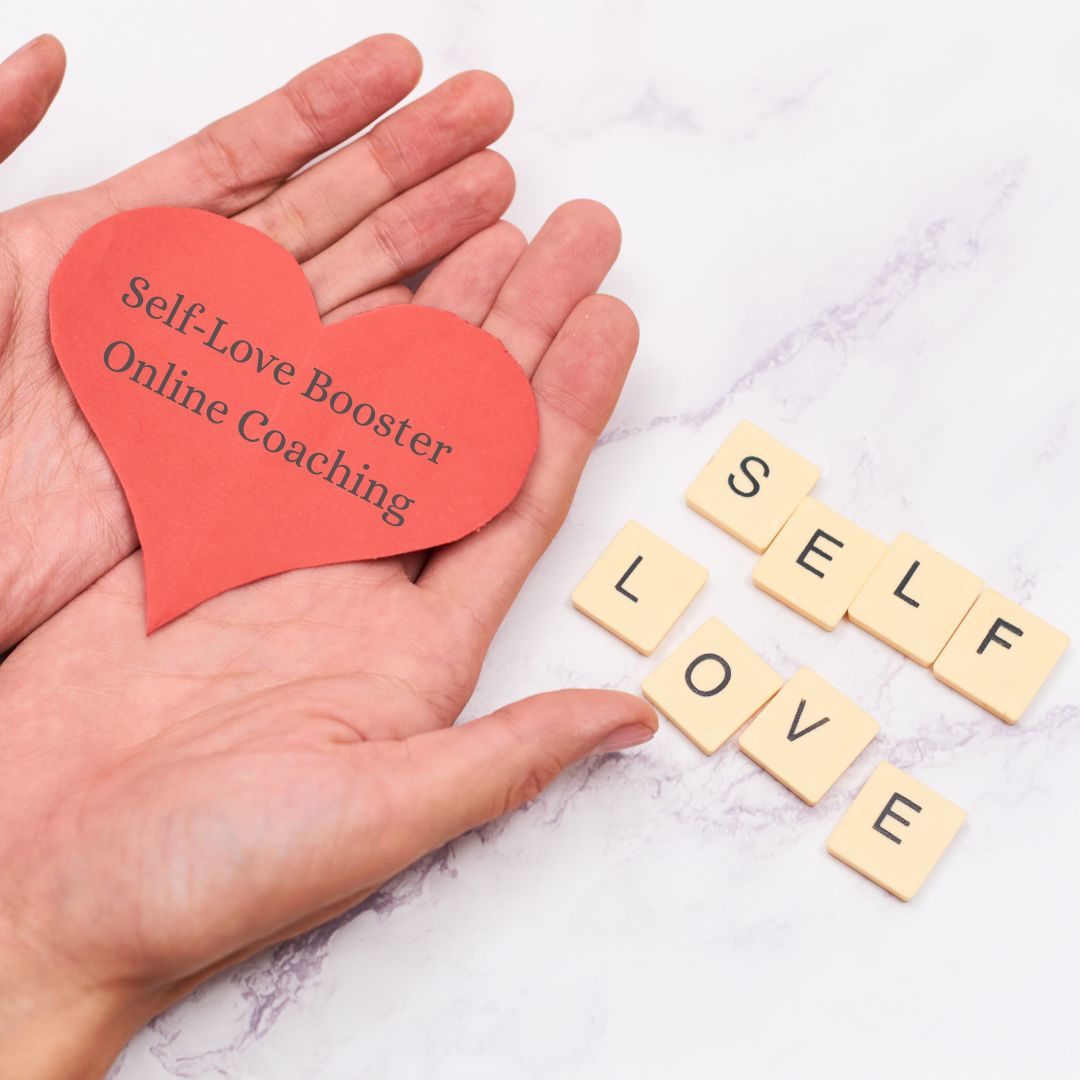 hands hold a red paper heartr with the text Self-Love Booster Online Coaching on it.